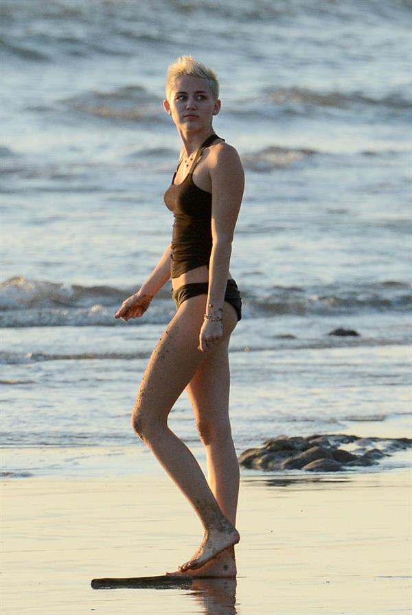 Miley Cyrus  yoga in black bikini on beach in Hawaii 1/24/13 