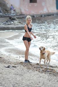Kimberley Garner in a black bikini on the beach in St. Tropez on July 31, 2014
