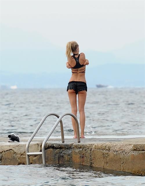 Kimberley Garner in a black bikini on the beach in St. Tropez on July 31, 2014