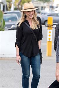 Julie Benz walking in jeans and a hat