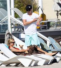 Paris Hilton at the beach in a skimpy red bikini and fishnet kaftan in Malibu.July 12, 2013