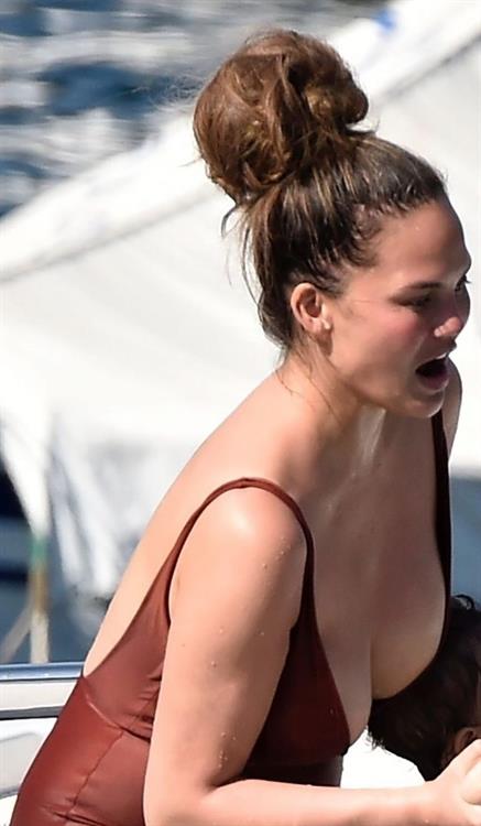 Chrissy Teigen sexy cleavage and ass in a swimsuit with her husband John Legend seen by paparazzi.
