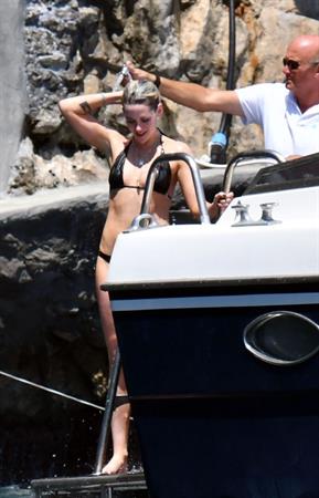 Kristen Stewart nude boobs caught topless by paparazzi tanning on a boat.
