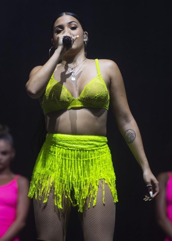 Mabel performing on stage singing in just a bra top showing off her boobs.
















