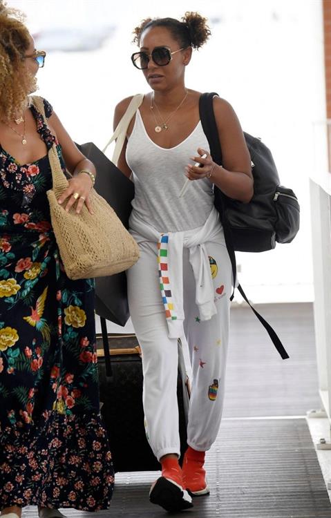 Melanie Brown Pictures Mel B braless boobs in a see through white top showing off her tits seen by paparazzi at the airport.