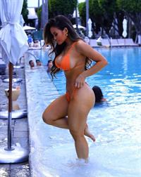Daphne Joy sexy ass in an orange thong bikini seen by paparazzi by the pool in Miami showing off her famous big boobs cleavage.