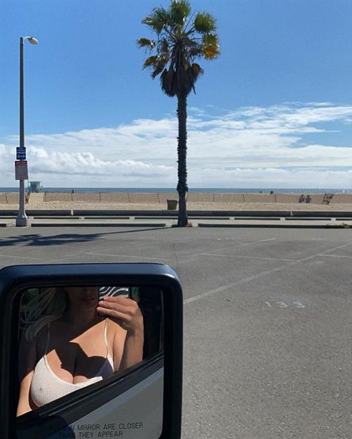 Lindsey Pelas Selfie Pictures Lindsey Pelas braless boobs showing off her big tits pokies and cleavage in a slightly see through white tank top in the mirror of her car.