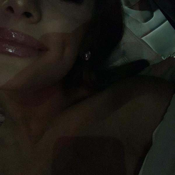 Ariana Grande topless covered new photo laying down showing off her sexy lips with gloss.