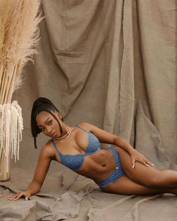 Normani boobs showing nice cleavage with her big tits in sexy see through lingerie matching blue lace bra and panties.